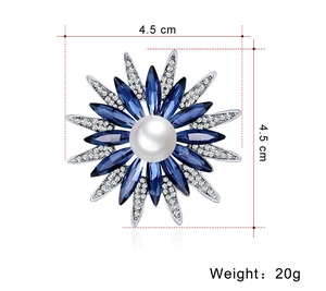 Dettaglio della spilla a fiore con cristalli blu, perla e dimensioni di 4,5 cm