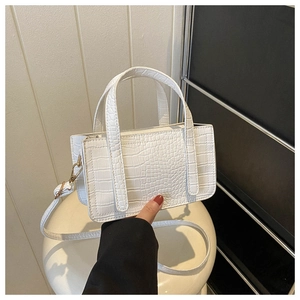 Detail of white crocodile pattern texture on a minimalist stylish small square handbag