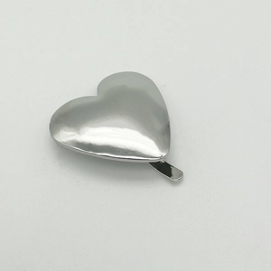 Detailed view of silver heart-shaped metal hair clip with smooth polished finish