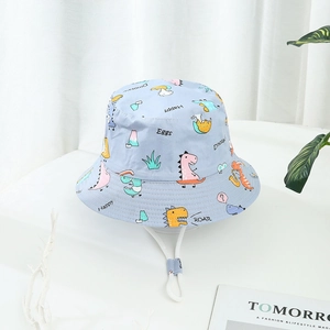Détail d'un chapeau de soleil bleu clair pour enfants avec motifs dinosaures et cordon