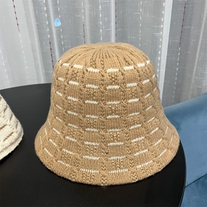 Close-up of camel knit bucket hat showing thick wool texture and white striped details