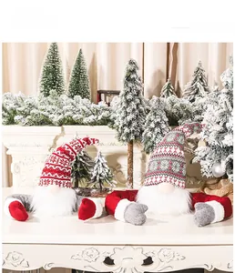 Detail of two Christmas gnomes with knit hats and white faux fur beards on snow background