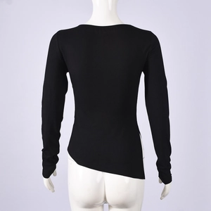 Detail of slim fit black long sleeve top featuring an asymmetric diagonal hemline design