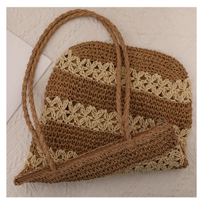 Detail of woven straw tote bag featuring hollow flower patterns and striped texture