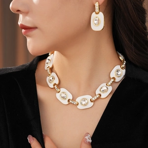 Gros plan d'un ensemble collier vintage en or et boucles d'oreilles ovales avec cristaux