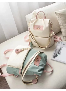 Detail of oxford backpack featuring back anti-theft zipper and striped shoulder straps