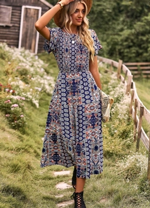 Robe longue bohème bleu foncé avec motifs ethniques présentée dans un décor rural naturel