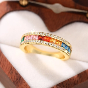 Close-up of rainbow zircon ring with square cut gemstones in a heart-shaped wooden box