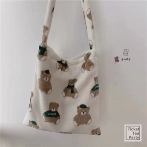 Detail of soft cream plush tote bag featuring cute cartoon bear patterns with LOVED text
