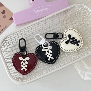 Y2K heart charms with ribbon detail in burgundy, black, and white on a basket