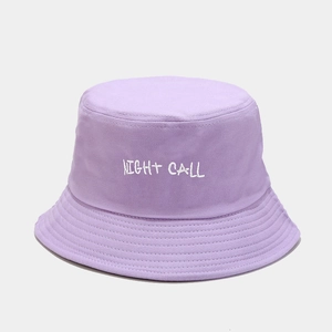 Detailed view of the 'NIGHT CALL' bold white embroidery on a lavender cotton bucket hat