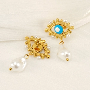 Golden Evil Eye earrings with blue enamel and large baroque pearl drops on silk background