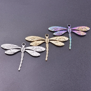 Detail of three dragonfly pendants in silver, gold, and rainbow finish with wing textures