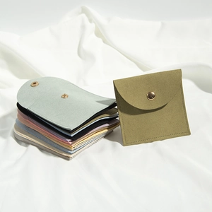 Various colorful microfiber jewelry pouches with snap button closure on silk background