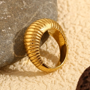 Detail of 18K gold plated croissant ring with ribbed texture on a stone pedestal