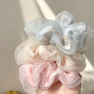 Three-pack mesh daisy floral scrunchies in light blue, yellow, and pink colors