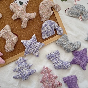 Close-up of pastel tweed Christmas ornaments including gingerbread man and star shapes