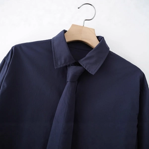 Fashionable dark blue cotton poplin long sleeve shirt with tie on a wooden hanger