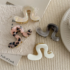 Set of four wavy acetate hair claws in pearl white, leopard pink, grey, and cream colors