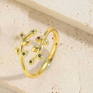 Detail view of a vintage gold leaf ring with colorful zircons on a natural stone base