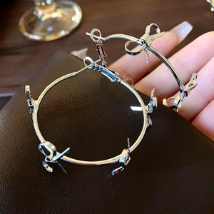Handheld view of large silver hoop earrings with a delicate bow knot accent