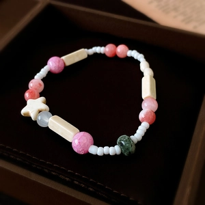 Makroaufnahme von Keramikperlen-Armband mit rosa Knisterperlen und Sternanhänger