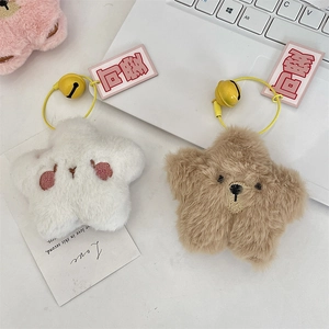 Close-up of star-shaped plush pendants with embroidered faces and small golden bells