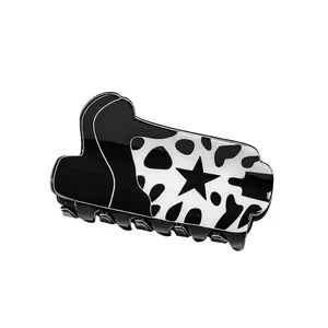 Star pattern hair claw clip with black and white cow print in glossy acrylic finish