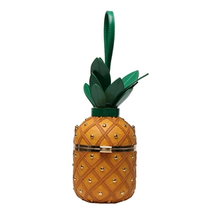 Close-up of pineapple bag featuring green leaf handle and golden stud details