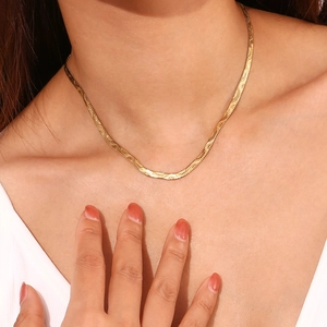 Polished 18K gold-plated snake chain necklace displayed on model neck and collarbone