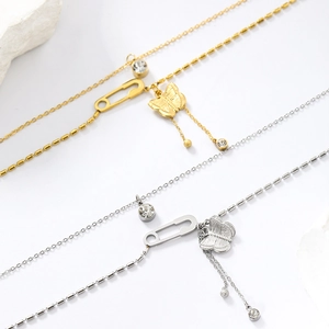 Detail view of gold and silver butterfly pendant necklaces with pin and crystal tassel charms
