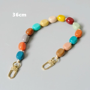 Macro detail of 36cm colorful resin bead bag strap with gold metal lobster clasps