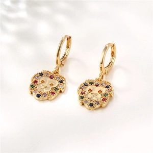 Golden lion head earrings with colorful zircon stones on white silk fabric background