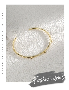 Detail view of gold plated adjustable open bangle with three sparkling cubic zirconia stones
