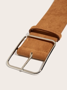 Detailed close-up of brown suede belt with polished silver rectangular buckle