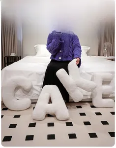 Detail of plush white fleece alphabet cushions CAKE arranged as bedroom decor