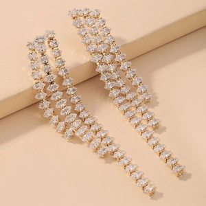 Macro shot of long gold-plated tassel earrings with sparkling marquise-cut crystals