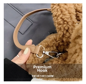 Detail of brown plush teddy fabric bag with silver metal spring hook and leather strap