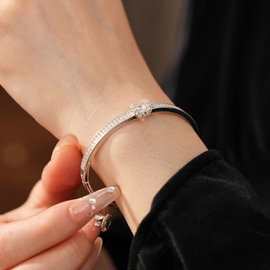 Macro view of silver bracelet featuring a pave-set diamond crown and polished band