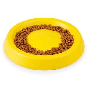 Top view of a yellow circular slow feeder dog bowl with dry food inside on a white background