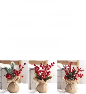 Detailed view of mini Christmas tree picks with red berries and burlap base