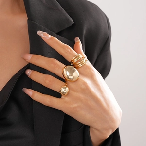 Three-piece gold oval chunky rings set worn by model in black blazer minimalist style