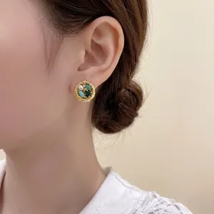 French vintage round gold earrings with green crystals and pearls shown on model