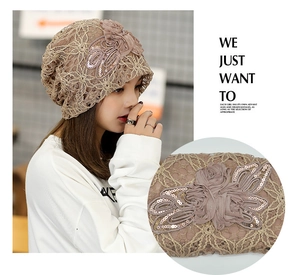 Detail of lace beanie with 3D floral accents and shimmering sequins in champagne gold