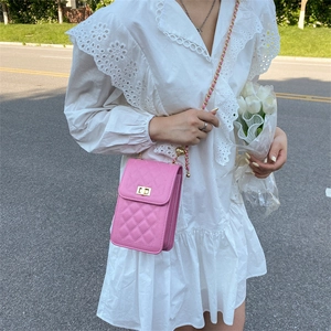 Pink quilted mini chain crossbody bag shown with a white dress in an outdoor setting