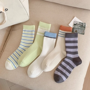 Gros plan détaillé de cinq paires de chaussettes en coton rayé aux couleurs pastel