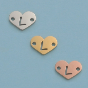 Macro view of 12mm mirror polished heart charms with L cutout in silver, gold, and rose gold