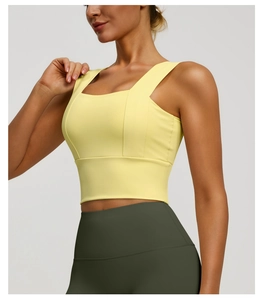 Detail view of the wide shoulder straps and elastic ribbed hem on yellow sports bra