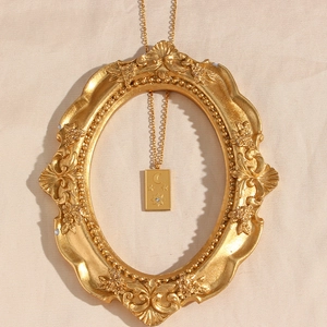 Gold tarot sun plaque necklace with white zircon on a vintage ornate golden frame