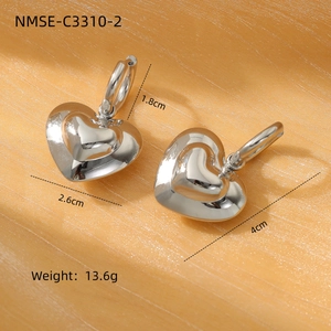 Silver stainless steel heart earrings with polished finish on orange satin background